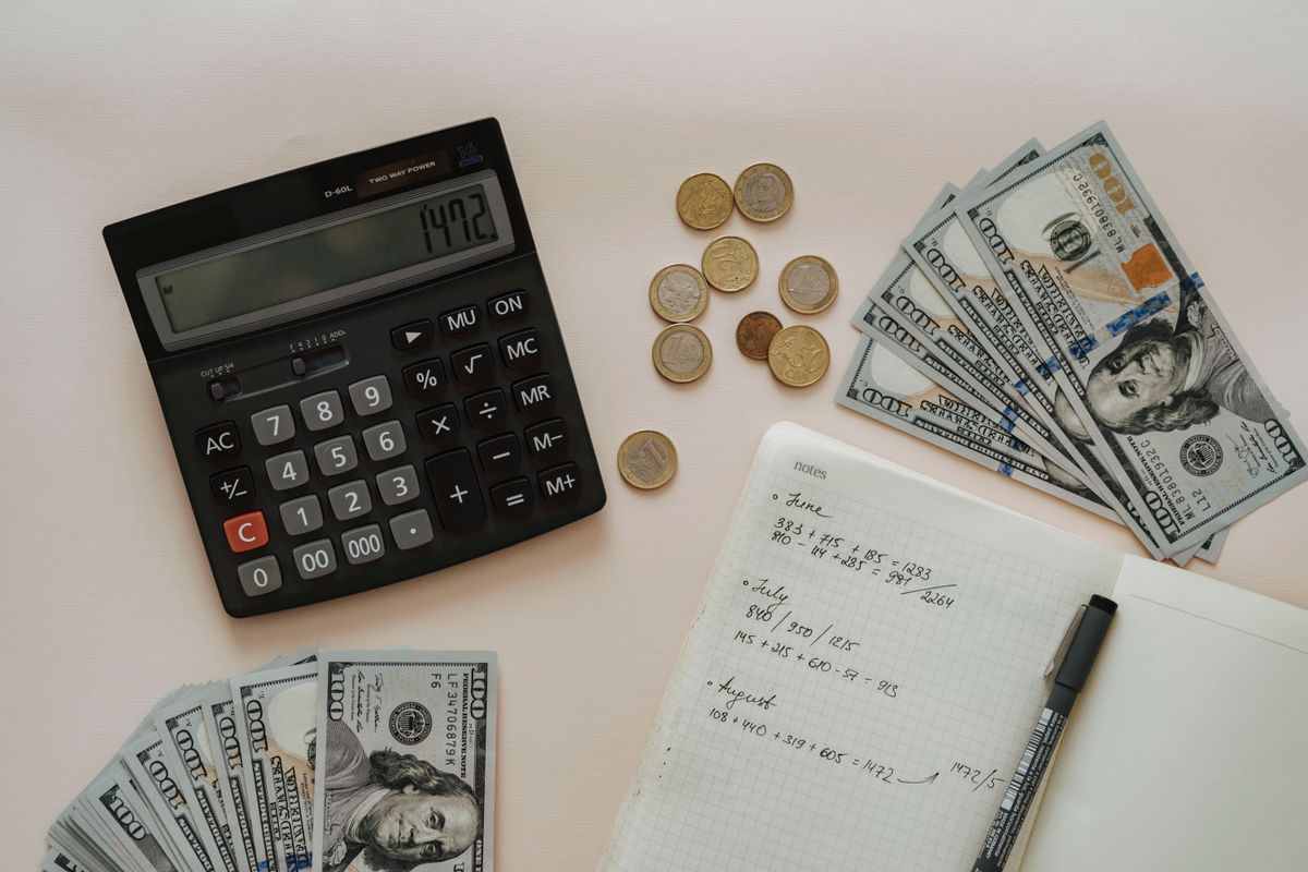 A calculator and notebook used for budgeting